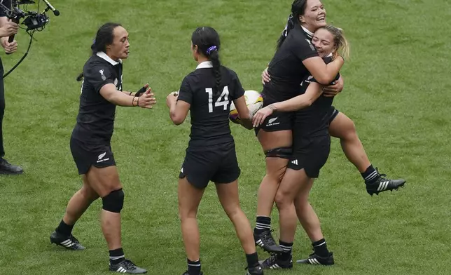 New Zealand's Renee Holmes, right, celebrates scoring their side's 3rd try of the game a try during the Women's Rugby World Cup bronze match between New Zealand and France at the Allianz Stadium, Twickenham, London, Saturday, Sept. 27, 2025. (Gareth Fuller/PA via AP)