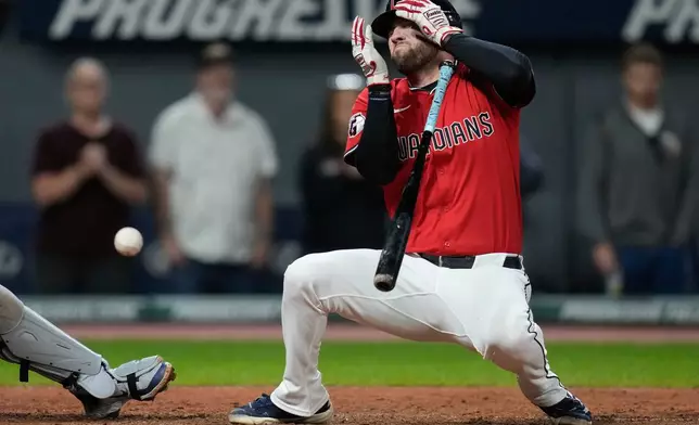 Cleveland Guardians' David Fry falls back after being hit in the face with his own bunt in the sixth inning of a baseball game against the Detroit Tigers in Cleveland, Tuesday, Sept. 23, 2025. (AP Photo/Sue Ogrocki)