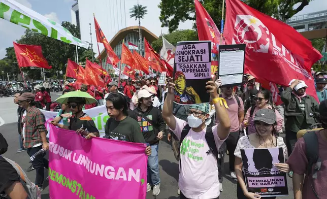 Protesters march as some hold a banner with writing reading "Guard democracy, uphold civil supremacy" during a protest against food price hikes and soaring taxes in Jakarta, Indonesia, Thursday, Sept. 4, 2025. (AP Photo/Achmad Ibrahim)