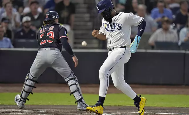 Tampa Bay Rays' Junior Caminero scores on an RBI single by Christopher Morel as the ball skips away from Cleveland Guardians catcher Bo Naylor during the first inning of a baseball game Thursday, Sept. 4, 2025, in Tampa, Fla. (AP Photo/Chris O'Meara)