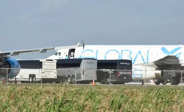 People board a plane in Harlingen, Texas Sunday, Aug. 31, 2025, as four charter buses are pulled into the side of the airport to unload dozens of passengers. (AP Photo/Valerie Gonzalez)