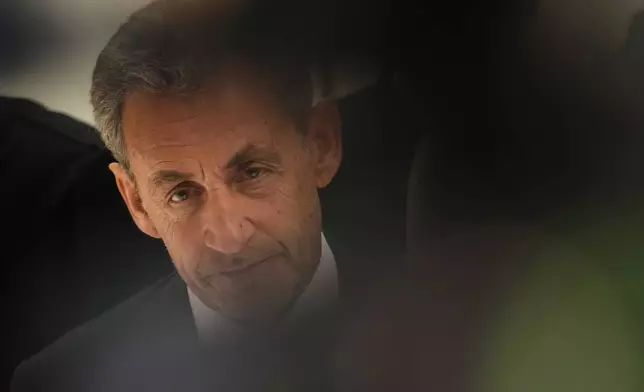 Former French President Nicolas Sarkozy pauses as he speaks with the media after a Paris court sentenced him to 5 years after finding him guilty of criminal conspiracy in an alleged scheme to finance his 2007 campaign with funds from Libya, Thursday, Sept. 25, 2025 in Paris. (AP Photo/Christophe Ena)