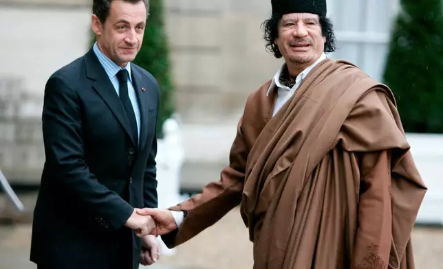 FILE - French President Nicolas Sarkozy, left, greets Libyan leader Col. Moammar Gadhafi upon his arrival on Dec. 10 2007 at the Elysee Palace, in Paris. (AP Photo/Francois Mori, File)