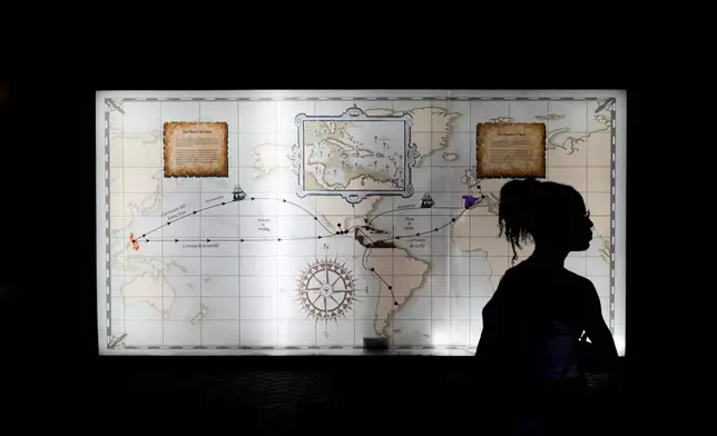 A tourist stands in front of a map outlining colonial interoceanic trade routes at the museum of Fort San Lorenzo, a 16th-century Spanish fortress that guarded the Caribbean entrance to the Chagres River, in Colon, Panama, Tuesday, Aug. 12, 2025. (AP Photo/Matias Delacroix)