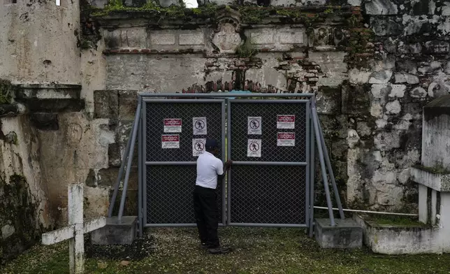 A security guard closes a gate of Fort San Jeronimo, a 17th-century Spanish fort that defended the Caribbean port of Portobelo, where treasure fleets loaded silver and gold for shipment to Europe, in Panama, Thursday, Aug. 14, 2025. (AP Photo/Matias Delacroix)