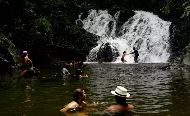 Tourists swim in a tributary of the Chagres River in Panama, once the main colonial waterway used to transport treasure in canoes and barges from the Pacific to the Caribbean for shipment to Spain, Saturday, Aug. 16, 2025. (AP Photo/Matias Delacroix)