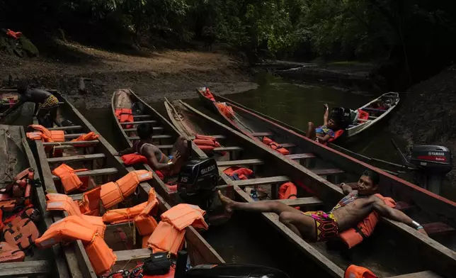 Embera Indigenous guides wait for the return of visitors touring the Chagres River, once the main colonial waterway carrying goods across Panama, between the Pacific Ocean and Caribbean, Saturday, Aug. 16, 2025. (AP Photo/Matias Delacroix)