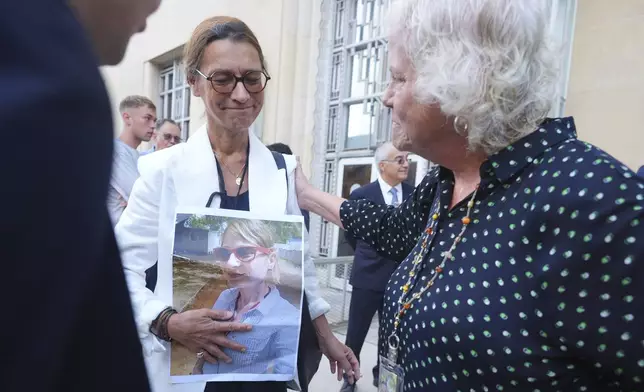 CORRECTS SPELLING OF LAST NAME TO GEOFFROY, NOT GEOFFREY - Family of the victims from the Boeing 737 MAX crashes Catherine Berthet, left, holds a photo of her deceased daughter Camille Geoffroy, as she is comforted by Susan Riffel, who lost sons Melvin and Bennett, before a hearing at federal court in Fort Worth, Texas, Wednesday, Sept. 3, 2025. (AP Photo/LM Otero)