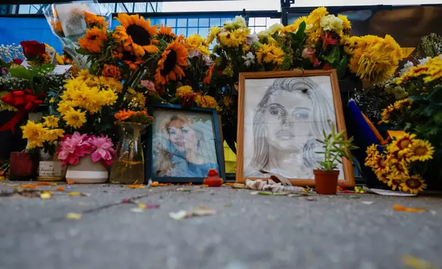 Flowers and photos are left near the tracks where Iryna Zarutska, who was fatally stabbed on a commuter train last month, Monday, Sept. 22, 2025, in Charlotte, N.C. (AP Photo/Nell Redmond)