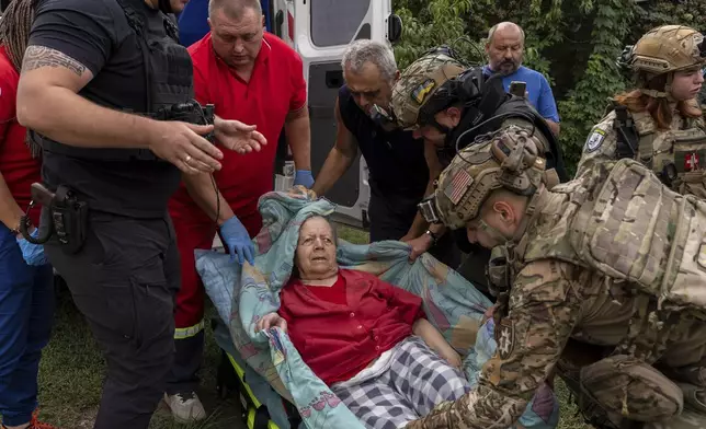 Police officers and medics evacuate Olha Trush, 86 from the village of Yarova, that was hit by Russian aerial strike, which killed dozens of civilians, in Sloviansk, Donetsk region, Tuesday, Sept.9, 2025. (AP Photo/Alex Babenko)