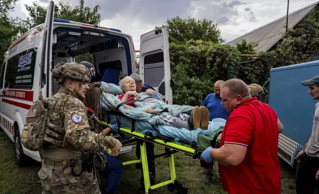 Policemen and medics transfer to the ambulance Olha Trush, 86 from the village of Yarova, that was hit by Russian aerial strike, which killed dozens of civilians, in Sloviansk, Donetsk region, Tuesday, Sept.9, 2025. (AP Photo/Alex Babenko)