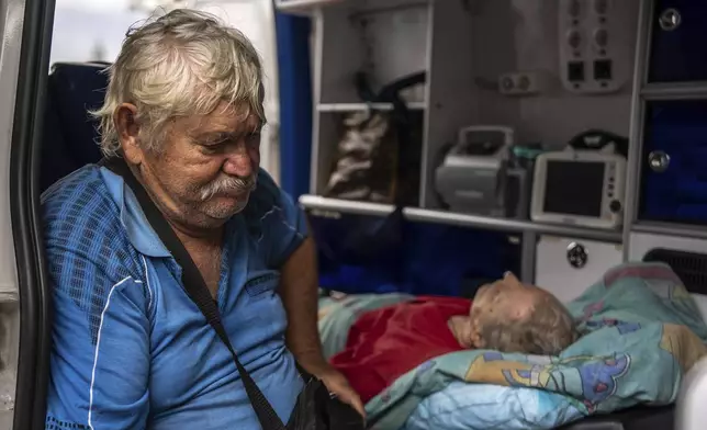 Myrola Puzyk, 70, who lost his wife Tetiana Puzyk, 68, who was killed while she was receiving her pension in the village of Yarova during a Russian aerial strike, seats in the ambulance during evacuation in Sloviansk, Donetsk region, Tuesday, Sept.9, 2025. (AP Photo/Alex Babenko)