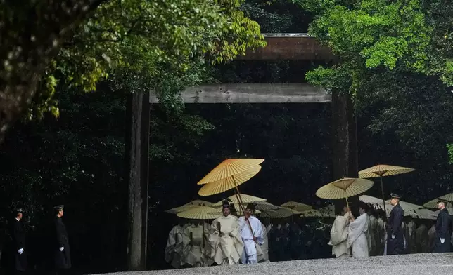 Priests and officials in the Shinto priesthood march as they start Yamaguchisai, a kickoff ceremony of the Shikinen Sengu ritual, which concludes in 2033, at Kotaijingu, also known as Naiku, or the inner sanctuary, of the Ise Jingu shrine complex in Ise, central Japan, Friday, May 2, 2025. (AP Photo/Hiro Komae)