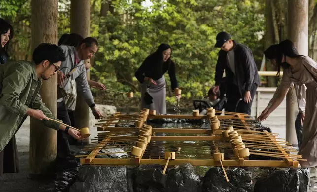 Visitors wash their hands to purify themselves as they visit the Ise Jingu shrine complex in Ise, central Japan, Thursday, May 1, 2025. (AP Photo/Hiro Komae)