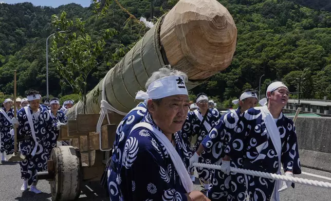 People pull a sacred timber felled in the previous day's Misomahajimesai, an early ceremony of the Shikinen Sengu ritual to rebuild main structures of the Ise Jingu shrine for Shinto deities, during a procession in local celebrations in Agematsu, central Japan, Wednesday, June 4, 2025. (AP Photo/Hiro Komae)