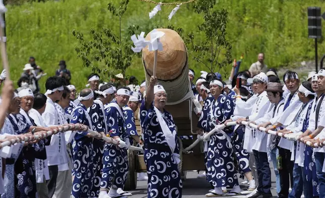 People make a rallying cry as they pull sacred timbers felled in the previous day's Misomahajimesai, an early ceremony of the Shikinen Sengu ritual to rebuild main structures of the Ise Jingu shrine for Shinto deities, during a procession in local celebrations in Agematsu, central Japan, Wednesday, June 4, 2025. (AP Photo/Hiro Komae)