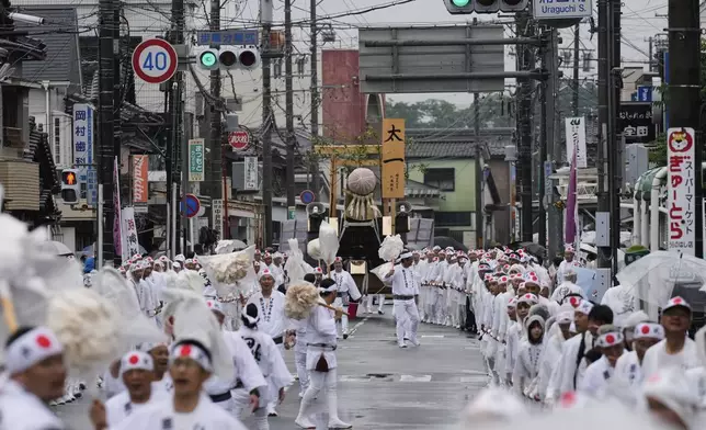 People pull a sacred timber towards Toyoukedaijingu, also known as Geku, or the outer sanctuary of the Ise Jingu shrine complex, during Mihishirogi Hoeishiki, a ceremony of the Shikinen Sengu ritual to rebuild its main structures for Shinto deities, in Ise, central Japan, Tuesday, June 10, 2025. (AP Photo/Hiro Komae)