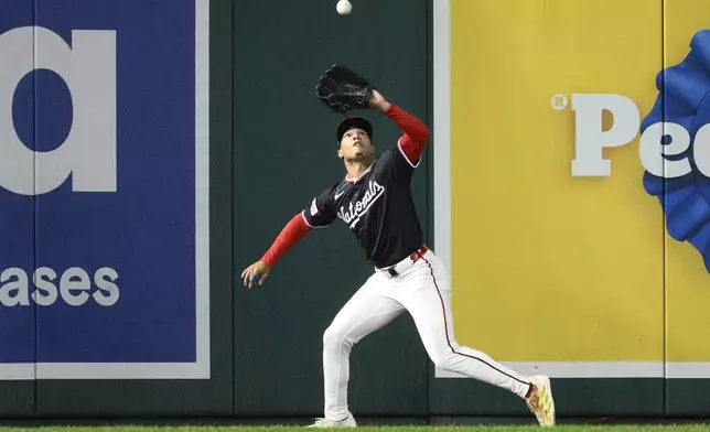 Washington Nationals left fielder Daylen Lile (51) makes a catch for the out on a fly ball by Atlanta Braves' Matt Olson during the first inning of the second baseball game of a doubleheader, Tuesday, Sept. 16, 2025, in Washington. (AP Photo/Nick Wass)