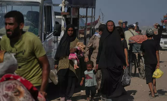 Displaced Palestinians flee northern Gaza Strip as they walk carrying their belongings along the coastal road, near Wadi Gaza, Tuesday, Sept. 23, 2025. (AP Photo/Abdel Kareem Hana)