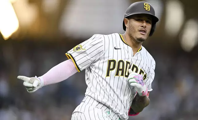 San Diego Padres' Manny Machado celebrates after hitting a solo home run during the third inning of a baseball game against the Colorado Rockies, Saturday, Sept. 13, 2025, in San Diego. (AP Photo/Denis Poroy)