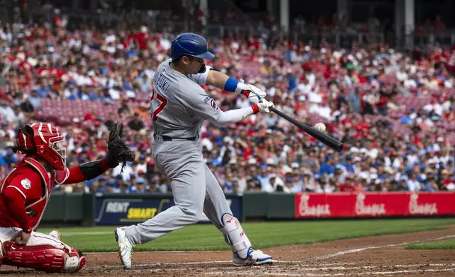 Chicago Cubs' Seiya Suzuki (27) makes contact with a pitch in the first inning of a baseball game against the Cincinnati Reds, Sunday, Sept. 21, 2025, in Cincinnati. (AP Photo/Michael Swensen)