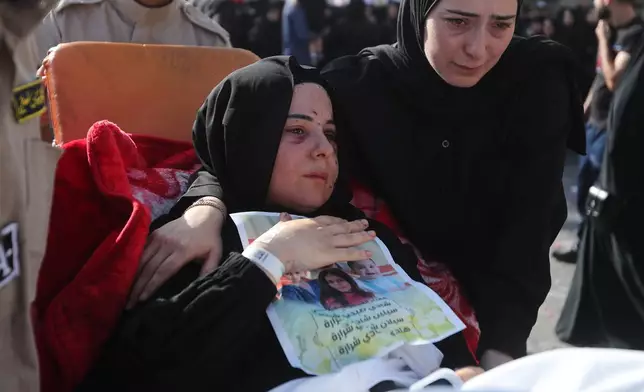 Carried on a stretcher, Amani Bazzi, mourns her husband Shadi Charara and three children, killed Sunday in an Israeli drone strike that hit their car, during the funeral procession in Bint Jbeil, southern Lebanon, Tuesday, Sept. 23, 2025. (AP Photo/Mohammed Zaatari)