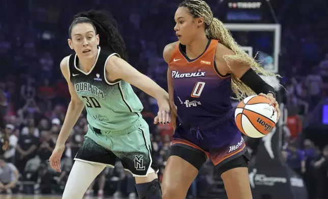 Phoenix Mercury forward Satou Sabally (0) shields the ball from New York Liberty forward Breanna Stewart (30) during the first half of Game 3 in the first round of the WNBA basketball playoffs, Friday, Sept. 19, 2025, in Phoenix. (AP Photo/Rick Scuteri)