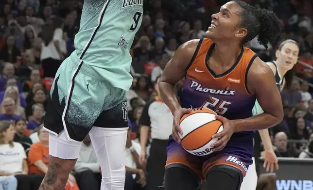 New York Liberty guard Natasha Cloud (9) defends against a shot by Phoenix Mercury forward Alyssa Thomas (25) during the first half of Game 3 in the first round of the WNBA basketball playoffs, Friday, Sept. 19, 2025, in Phoenix. (AP Photo/Rick Scuteri)