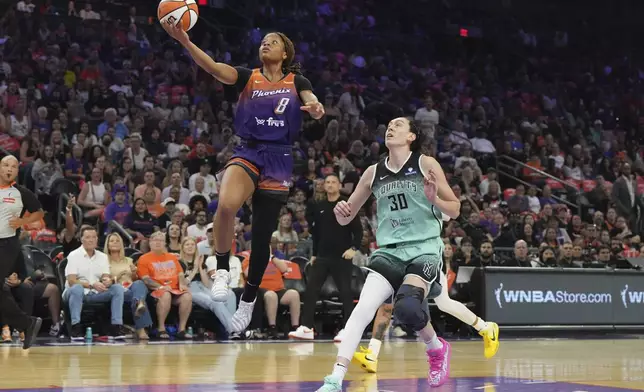 Phoenix Mercury guard Monique Akoa Makani (8) drives past New York Liberty forward Breanna Stewart (30) during the first half of Game 3 in the first round of the WNBA basketball playoffs, Friday, Sept. 19, 2025, in Phoenix. (AP Photo/Rick Scuteri)