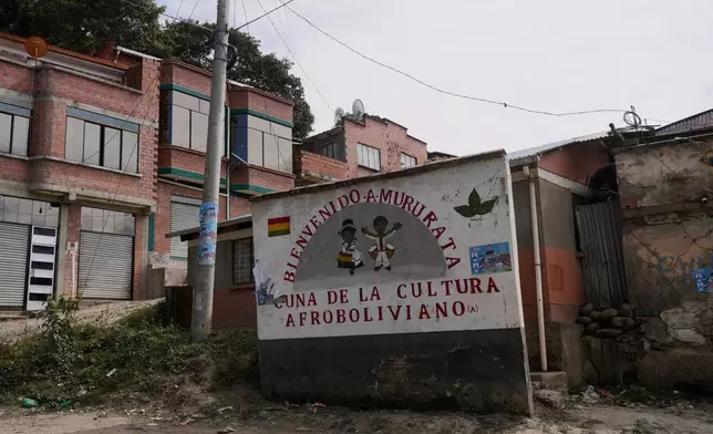 A sign with a message that reads in Spanish: “Welcome to Mururata, cradle of Afro-Bolivian culture” stands at the entrance of Mururata, Bolivia, Sunday, Aug. 3, 2025. (AP Photo/Juan Karita)
