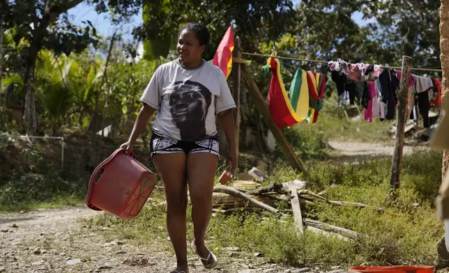 An Afro-Bolivian woman walks away after hanging laundry to dry, near Tocana, in Los Yungas region of Bolivia, Sunday, Aug. 3, 2025. (AP Photo/Juan Karita)