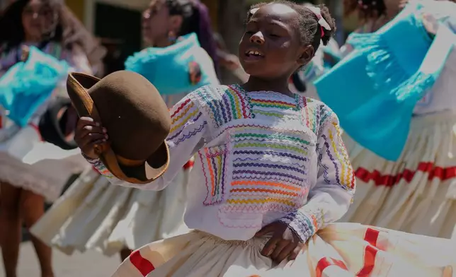 A young member of the Afro-Bolivian community dances the “saya,” a traditional dance performed with drums and chants, as part of the celebrations to mark the upcoming National Day of Afro-Bolivian people, in La Paz, Bolivia, Friday, Sept. 19, 2025. (AP Photo/Juan Karita)