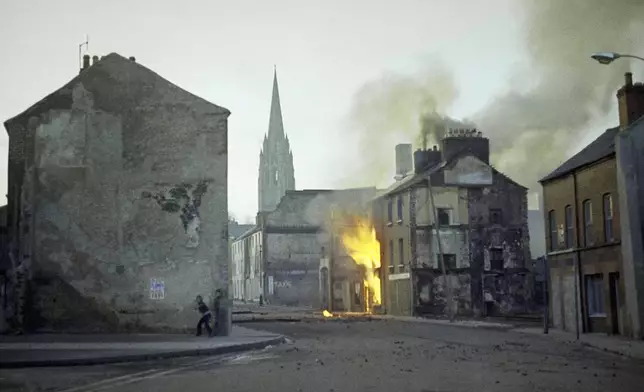 FILE - A building burns in the bogside district of Londonderry, Northern Ireland, in the aftermath of Bloody Sunday, in February 1972. (AP Photo/Michel Laurent, File)