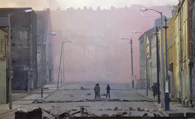 FILE - Haze from smoke bombs released by British troops in the bogside district of Londonderry, Northern Ireland, on Feb. 1, 1972. (AP Photo/Michel Laurent, File)
