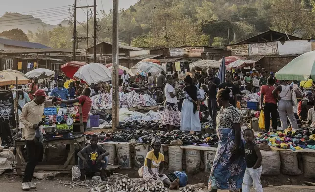 A woman and a child walk past a market in Zomba, Malawi, Wednesday, Sept. 10, 2025. (AP Photo/Thoko Chikondi)
