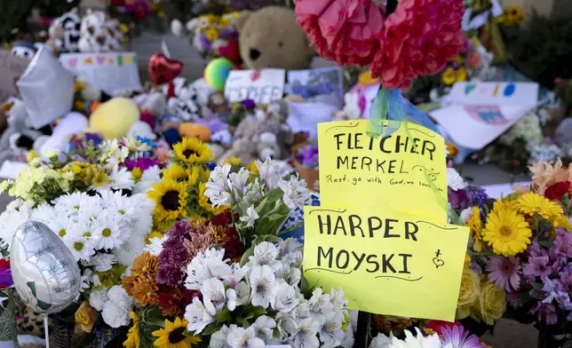 A sign honors the two victims who died in Wednesday's shooting, 8-year-old Fletcher Merkel and 10-year-old Harper Moyski, outside Annunciation Catholic Church, Sunday, Aug. 31, 2025, in Minneapolis. (AP Photo/Ellen Schmidt)
