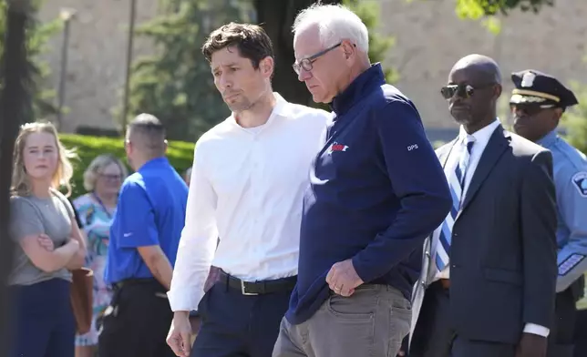 Minnesota Gov. Tim Walz, right, walks with Minneapolis Mayor Jacob Frey outside the Annunciation Catholic School following a shooting Wednesday, Aug. 27, 2025, in Minneapolis. (AP Photo/Bruce Kluckhohn)