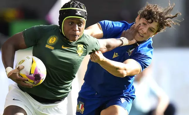 South Africa's Zintle Mpupha, left, attempts to get past Italy's Aura Muzzo during the Women's Rugby World Cup 2025 Pool D match between Italy and South Africa at at York Community Stadium, in York, England, Sunday Aug. 31, 2025. (Danny Lawson/PA via AP)