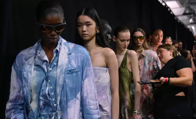 Models wear creations part of the Diesel's Spring Summer 2026 collection in the backstage ahead of the collection's show, in Milan, Italy, Tuesday, Sept. 23, 2025. (AP Photo/Antonio Calanni)