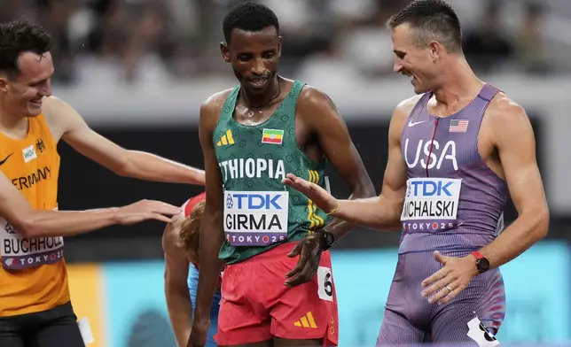 United States' Daniel Michalski, right, speaks with Ethiopia's Lamecha Girma, center, and Germany's Niklas Buchholz after competing in the men's 3,000 meters steeplechase heat at the World Athletics Championships in Tokyo, Saturday, Sept. 13, 2025. (AP Photo/Eugene Hoshiko)