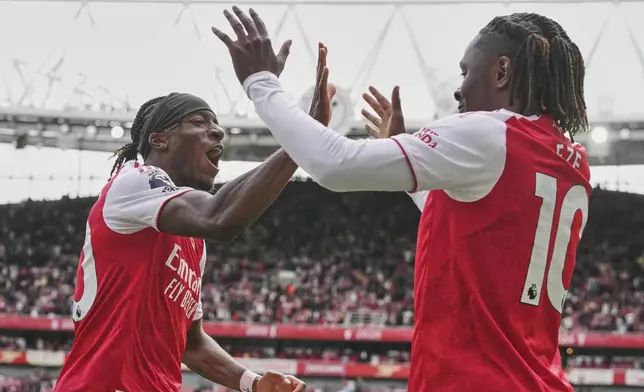 Arsenal's Noni Madueke, left, and Eberechi Eze celebrate after a goal during the Premier League soccer match between Arsenal and Nottingham Forest in London, Saturday, Sept. 13, 2025. (AP Photo/Kin Cheung)