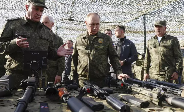 Russian President Vladimir Putin, centre, accompanied by Commander-in-Chief of the Russian Ground Forces Andrey Mordvichev, left, inspects Russian weapons and equipment during his visit to the Russian-Belarusian joint military drills "Zapad 2025" (West 2025) at the Mulino training ground in Nizhny Novgorod region, Russia, Tuesday, Sept. 16, 2025. (Mikhail Metzel/Sputnik, Kremlin Pool Photo via AP)