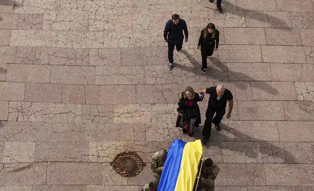 Honor guards carry the coffin of Artem Antonenko, a Ukrainian serviceman, during his funeral ceremony in the center of Kyiv, Ukraine, Friday, Sept. 19, 2025. (AP Photo/Evgeniy Maloletka)