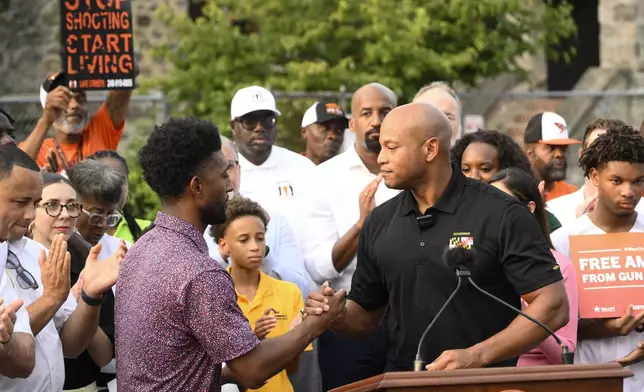 Maryland Gov. Wes Moore, right, shakes hands with Baltimore mayor Brandon Scott, left, Friday, Sept. 5, 2025, in Baltimore. (AP Photo/Nick Wass)