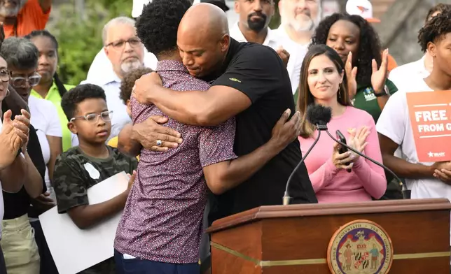 Maryland Gov. Wes Moore, right, hugs Baltimore mayor Brandon Scott, left, at a news conference, Friday, Sept. 5, 2025, in Baltimore. (AP Photo/Nick Wass)