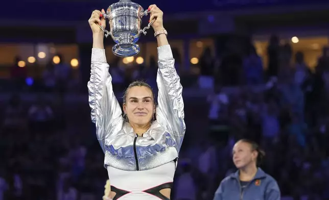 Aryna Sabalenka, of Belarus, holds up the championship trophy after defeating Amanda Anisimova, of the United States, in the women's singles final of the U.S. Open tennis championships, Saturday, Sept. 6, 2025, in New York. (AP Photo/Kirsty Wigglesworth)