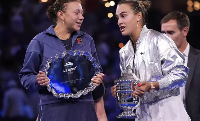 Aryna Sabalenka, of Belarus, and Amanda Anisimova, of the United States, jhold their trophies after the women's finals of the U.S. Open tennis championships, Saturday, Sept. 6, 2025, in New York. (AP Photo/Yuki Iwamura)