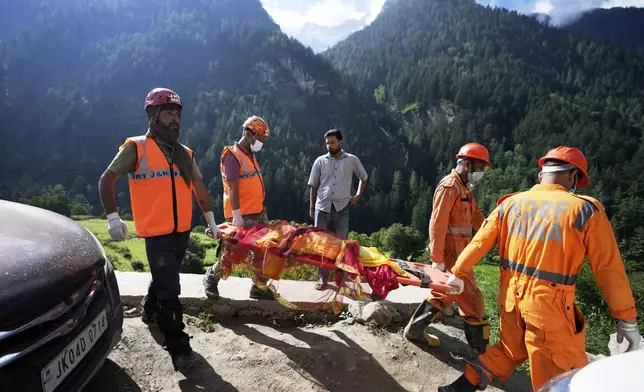 FILE - India's National Disaster Response Force (NDRF) personnel carry a dead body on a stretcher during rescue operations after Thursday's flash floods in Chositi village, Kishtwar district, Indian-controlled Kashmir, Aug. 16, 2025. (AP Photo/Channi Anand, File)