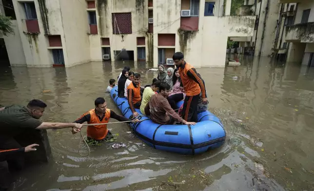 FILE - Members of the State Disaster Response Force (SDRF) rescue students stranded in a hostel due to flooding caused by heavy rains in Jammu, India, Aug. 24, 2025. (AP Photo/Channi Anand, File)