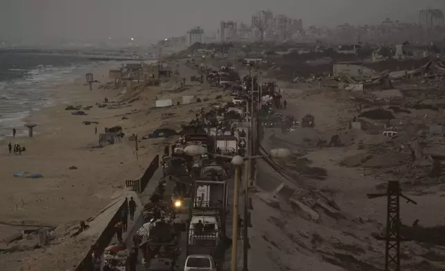Displaced Palestinians fleeing northern Gaza carry their belongings along the coastal road toward southern Gaza, Thursday, Sept. 11, 2025, after the Israeli army issued evacuation orders from Gaza City. (AP Photo/Jehad Alshrafi)